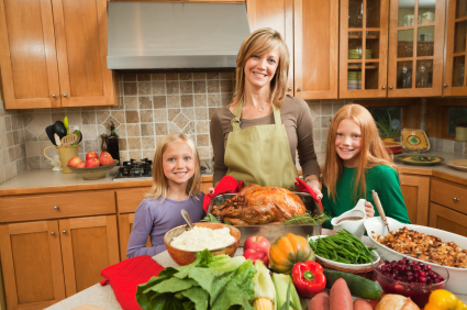 Mother and children preparing Thanksgiving dinner in home kitchen